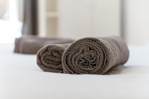 a pile of towels sitting on a bed at Orange Suite - The House Of Travelers in Como +45 photos