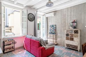 a living room with a red couch and a clock at Orange Suite - The House Of Travelers in Como