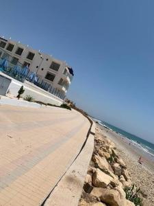 - un bâtiment sur une plage à côté de l'océan dans l'établissement Appartement pied dans l’eau à 10 min d’Agadir, à Aourir