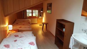 a bathroom with two beds and a sink in a room at Landgasthof Tännler in Innertkirchen