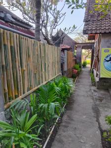 una cerca frente a una casa con plantas en Lumbung Sari Home Stay, en Amed
