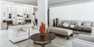 a living room with white furniture and a table at Apollo Resort in Agia Marina Aegina