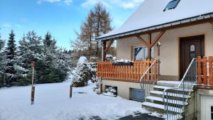una casa con un porche cubierto de nieve y escaleras en Ferienwohnung Renner en Kurort Altenberg