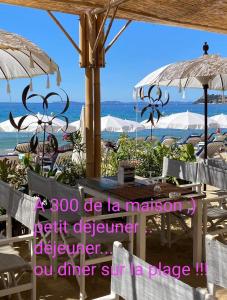 una spiaggia con sedie e ombrelloni e l'oceano di La demeure de Poulpican chambre BROCELIANDE jacuzzi charme et romantique mer plage restaurant à 300m Golfe Saint Tropez a La Croix-Valmer