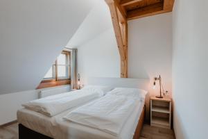 een slaapkamer met een wit bed en een raam bij Apartmány Staré Město in Znojmo
