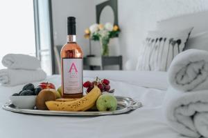 a bottle of wine and a plate of fruit on a table at Apollo Resort in Agia Marina Aegina