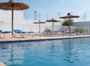 einen Pool mit Stühlen, Sonnenschirmen und Wasser in der Unterkunft Casa Rural Frigols in Chella