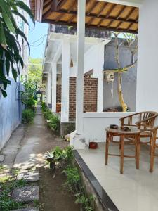 a porch of a house with a table and chairs at Lumbung Sari Home Stay in Amed