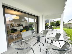 un gruppo di sedie e un tavolo su un patio di Grand appartement neuf de standing – Top Cosy a Larmor-Plage
