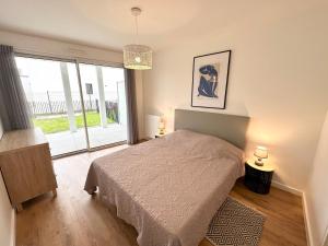 una camera con un letto e una grande finestra di Grand appartement neuf de standing – Top Cosy a Larmor-Plage