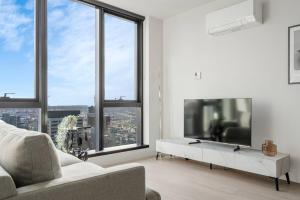 uma sala de estar com um sofá e uma grande janela em Elegant 1B apt in central Melbourne w unreal view#PA4303 em Melbourne