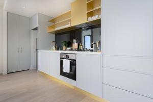 uma cozinha com armários brancos e uma bancada em Elegant 1B apt in central Melbourne w unreal view#PA4303 em Melbourne