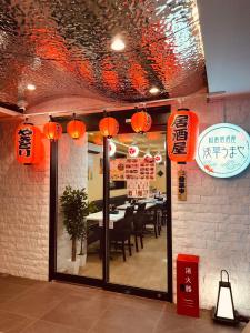 Ano Hotel Asakusa في طوكيو: مطعم به فوانيس برتقالية وغرفة طعام