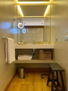 a bathroom with a sink and a mirror and a stool at Residence Dalco Suites & Apartments in Limone sul Garda
