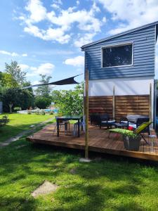 eine Terrasse mit einem Picknicktisch und einem Sonnenschirm in der Unterkunft Gîte du Moulin de Tart le Bas 
