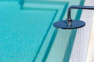 un cabezal de ducha con agua goteando junto a la piscina en Myko Villa by Bestofmikonos, en Ornos