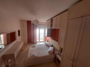 a small room with a bed and a desk in it at Redsun City Center Apartment in Vlorë