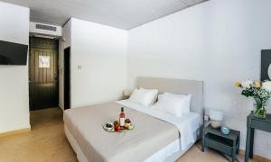 a hotel room with a bed with a bowl of fruit on it at Apollo Resort in Agia Marina Aegina