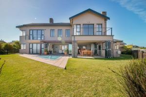 a large house with a yard with a pool at Pezula Luxury Villa SW2 in Knysna