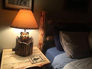 uma lâmpada sobre uma mesa ao lado de uma cama em Tahoe Cottage perfect for couples and outdoor enthusiasts em South Lake Tahoe