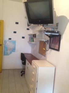 a room with a desk with a television on a wall at Nega Maluca Guesthouse in Salvador