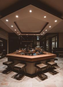 a large kitchen with a large island with stools at Apollo Resort in Agia Marina Aegina