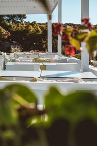 a group of white tables and chairs in a yard at Apollo Resort in Agia Marina Aegina