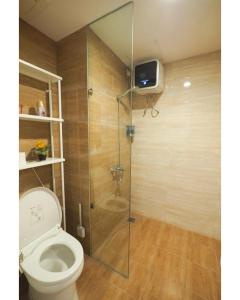 a bathroom with a toilet and a tv on the wall at Breeze Home in Pondoklang