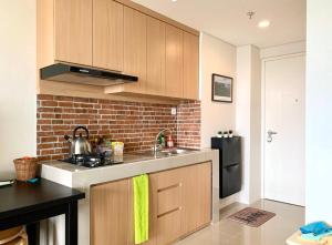 a kitchen with a sink and a brick wall at Breeze Home in Pondoklang