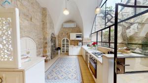 une cuisine avec un grand mur en pierre dans l'établissement VILLA MAMILLA - Boutique suites, à Jérusalem