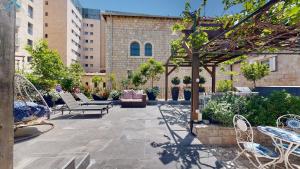 a patio with chairs and tables in a building at VILLA MAMILLA - Boutique suites in Jerusalem