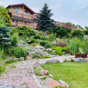 una casa en una colina con un camino de piedra delante en Agroturystyka "U Klaudii", en Mikołajki