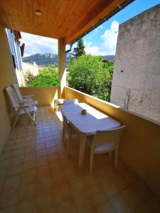 a porch with a table and chairs on a balcony at L' Alto - 80m2, Grand Terrasse avec vue sur le Cap, à 200m des plages in Cassis