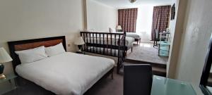 ein Schlafzimmer mit 2 Betten und einem Kinderbett in der Unterkunft Britannia Hotel City Centre Manchester in Manchester