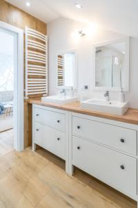 a bathroom with two sinks and a large mirror at Apartamenty Defala i Strefa Relaksu Natural Touch in Rymanów-Zdrój