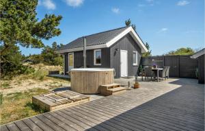 a small house with a deck and a table at 3 Bedroom Pet Friendly Home In Blvand in Blåvand