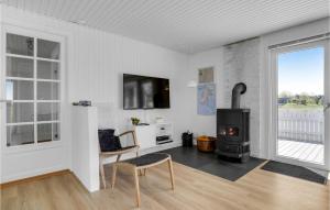 a living room with a wood stove and a tv at 3 Bedroom Pet Friendly Home In Blvand in Blåvand