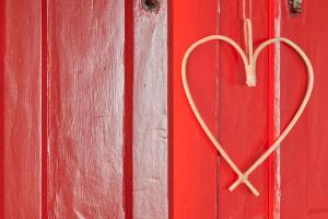 a heart shaped heart hanging on a red door at Rustic & Aesthetic House in Alqueva with Pool in Granja