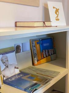 una estantería con libros y otros libros en Sacred Way rooftop apartment en Atenas