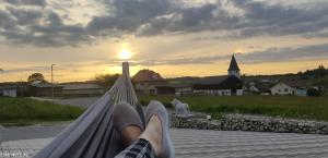 a person sitting on a hammock watching the sunset at Durchreisestop mit Kinder am außergewöhnlichen Spitzboden mit Autobetten und Bad ,Küche im Souterain in Deining