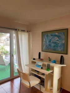 Zimmer mit einem Schreibtisch, einem Stuhl und einem Fenster in der Unterkunft Sacred Way rooftop apartment in Athen