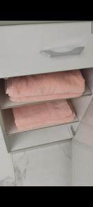 ein Regal mit drei Handtüchern in einer weißen Schublade in der Unterkunft Durchreisestop mit Kinder am außergewöhnlichen Spitzboden mit Autobetten und Bad ,Küche im Souterain in Deining