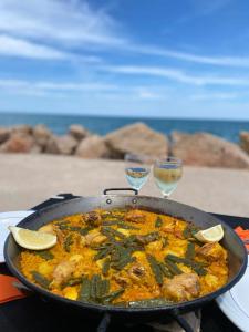 a pan of food and two glasses of wine at BLUE DOUBLE PRIVATE ROOM AT FRONT BEACH - HABITACION DOBLE en la playa in Valencia