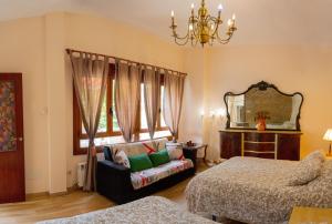 um quarto com uma cama, um sofá e um espelho em Casa As Marismas entre Razo y Baldayo em Lema