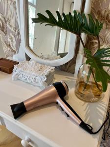 a knife on a table with a vase and a mirror at Stirling Cottage in Durban