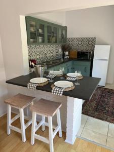 a kitchen with a island with two stools and a counter top at Stirling Cottage in Durban