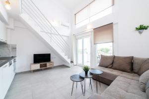 sala de estar con sofá y TV en Nefeli Residential Complex, en Ofrinion