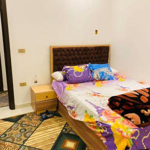 um quarto com uma cama e uma cabeceira em madeira em 6 اكتوبر مدينه الشيخ زايد em Sheikh Zayed