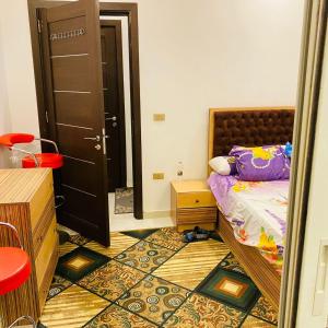um pequeno quarto com uma cama e uma porta em 6 اكتوبر مدينه الشيخ زايد em Sheikh Zayed