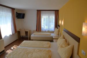 a hotel room with two beds and a window at Gasthof Roitner in Ebensee